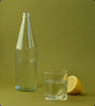 Fles water met citroen en glas